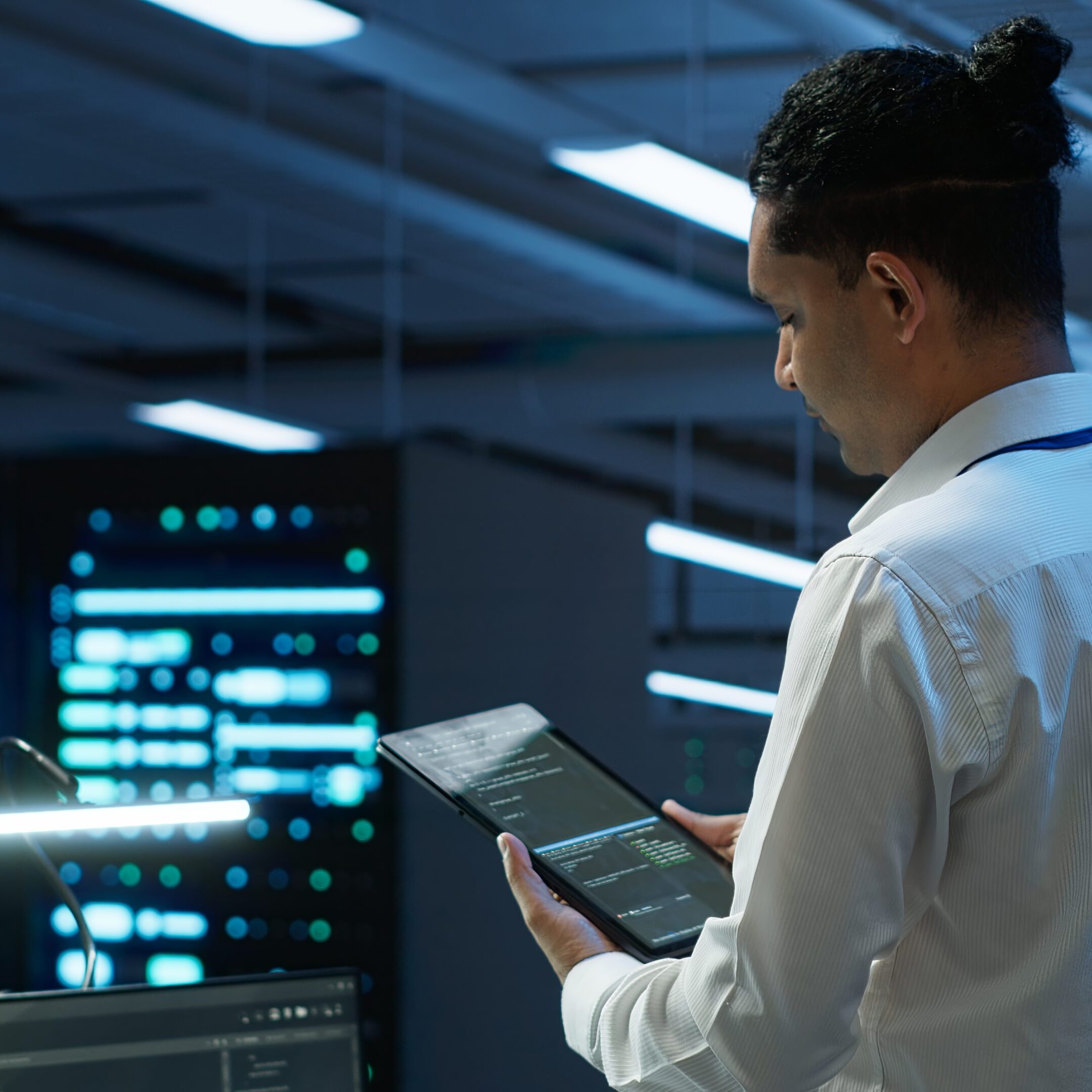 Person using tablet in a server room.